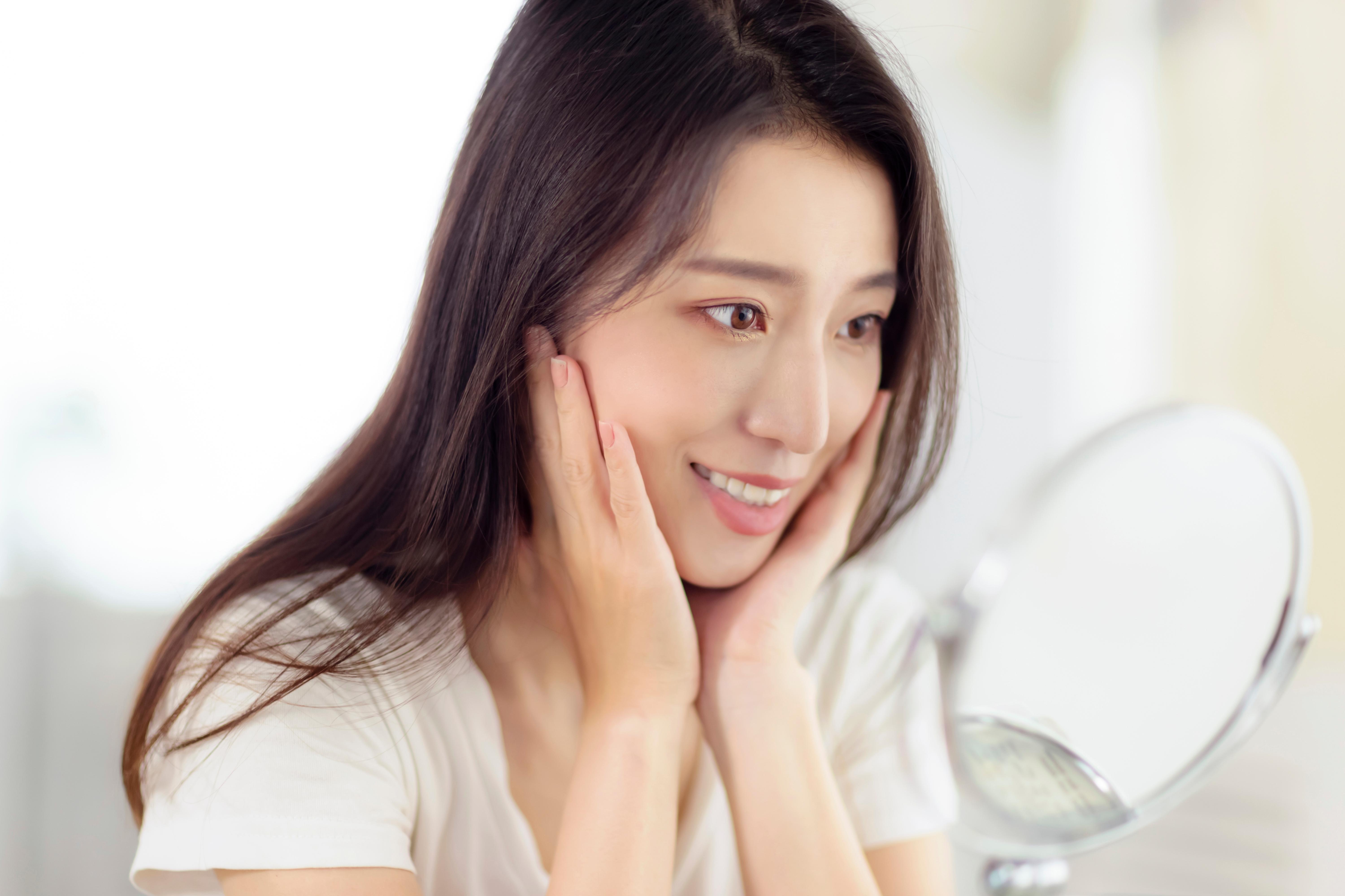 asian-young-woman-looking-her-face-mirror