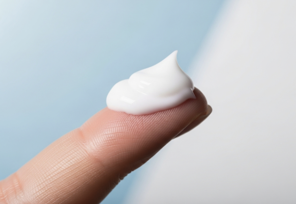 A fingertip holding a dollop of lightweight moisturizer, symbolizing the final step of hydration.